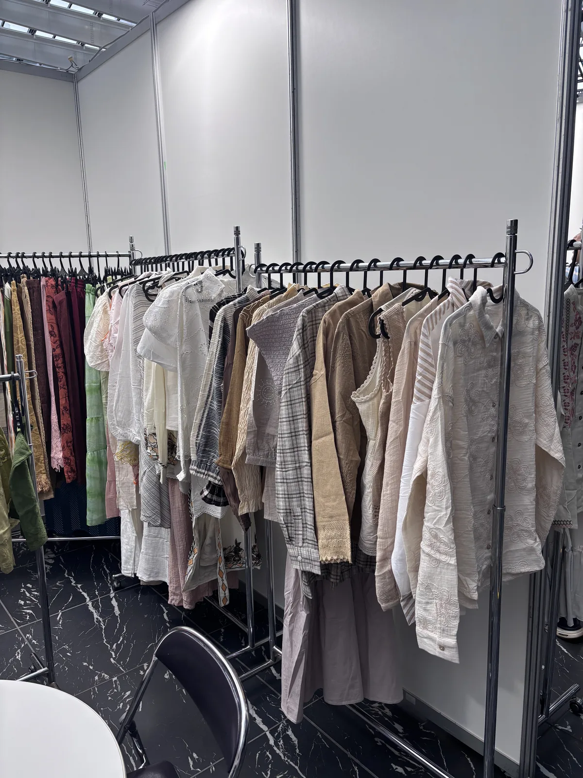 Rails of blouses and shirts at the Myra Enterprises stand, Tokyo 2026